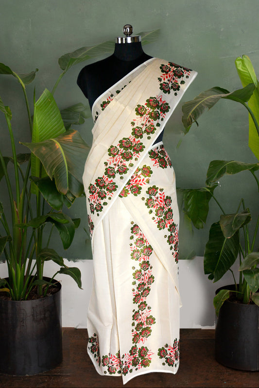 White saree with floral embroidery on a mannequin against a green wall with plants.